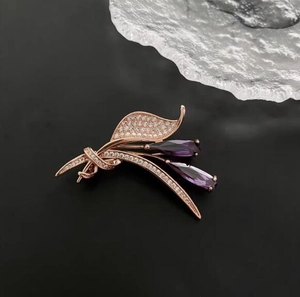 Détail d'une broche florale avec pierres violettes en poire et zircons pavés