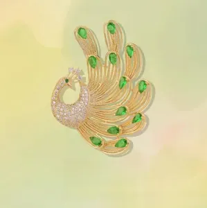 Detailed close-up of peacock brooch featuring green emerald-like stones and crystals