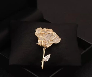 Macro detail of luxury gold rose brooch featuring brilliant pave crystal inlay craftsmanship
