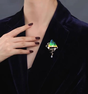 Detail of Chinese style landscape brooch with pearls on a dark blue velvet suit jacket