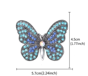 Dettaglio macro di spilla a farfalla di lusso con cristalli blu e viola, 4,5 x 5,7 cm