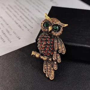 Vintage luxury owl brooch featuring champagne diamonds and vibrant emerald crystal eyes