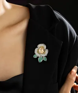 Détail d'une broche camélia élégante avec cristal champagne et pavé de diamants sur veste