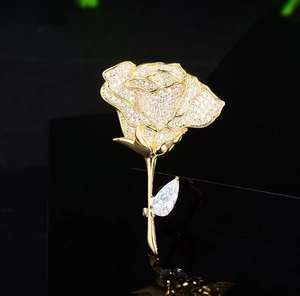 Close-up of elegant rose brooch featuring sparkling pavé diamonds and a teardrop gemstone