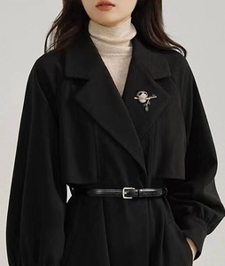 Détail d'une broche panda avec strass sur le revers d'un manteau noir élégant