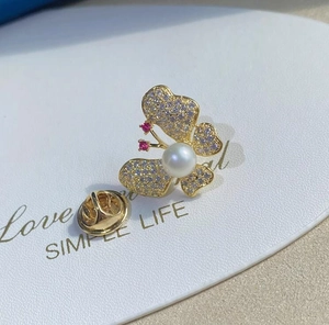 Gros plan détaillé d'une broche papillon avec perles et strass scintillants