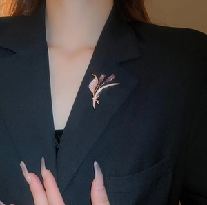 Détail de la broche tulipe avec pierres roses et cristaux sur un revers de veste noir