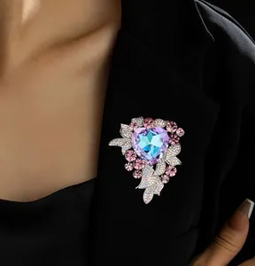 Detailed macro of heart-shaped crystal brooch with pink stones and silver leaf accents