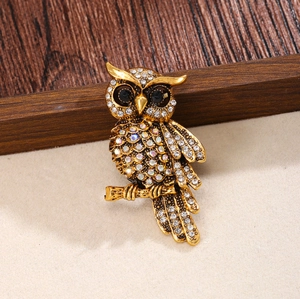Luxurious vintage gold owl brooch featuring sparkling crystal rhinestones and black gem eyes