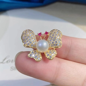 Broche papillon dorée avec des perles chatoyantes et des cristaux micro-pavés élégants