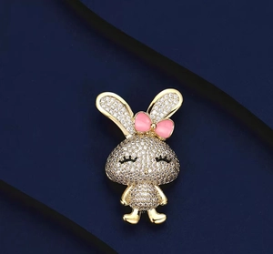 Détail en gros plan d'une broche lapin avec des zircons brillants et un nœud rose