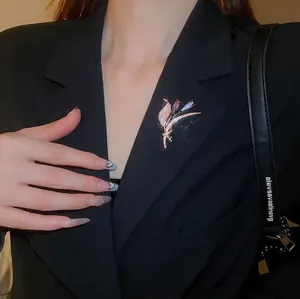 Broche fleur plaquée or élégante avec cristaux violets sur un revers de blazer noir