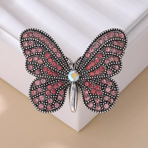 Elegante spilla a farfalla d'argento con strass rosa e rossi su supporto in pelle