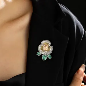 Broche fleur élégante avec pierre jaune et cristaux blancs sur revers de costume noir