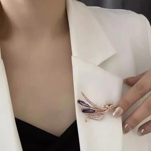 Élégante broche en or rose avec cristaux violets et zircons blancs sur veste blanche