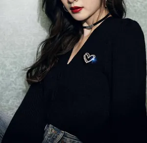 Détail de la broche coeur en perles et strass sur un pull en maille noir
