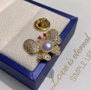 Broche papillon dorée avec des strass étincelants et une perle de lavande raffinée
