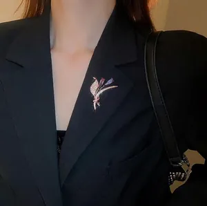 Broche fleur dorée élégante avec pierres violettes sur un veston de costume noir