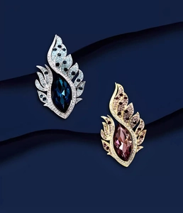 Détail de broches en forme d'aile avec cristaux bleu et magenta et strass étincelants