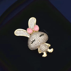 Broche lapin mignonne avec cristaux blancs et nœud rose sur alliage doré brillant