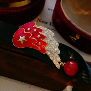 Broche étoile dorée de luxe avec queue en émail rouge et strass sur fond en velours