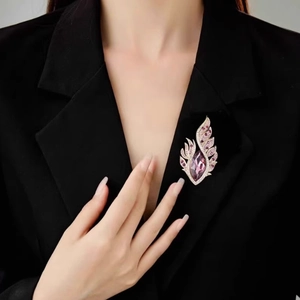 Broche ailes en cristal avec pierre marquise violette sur le revers d'un tailleur noir