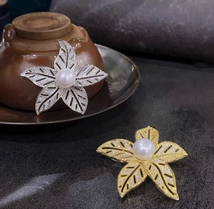Détail d'une broche à cinq pétales avec cristaux de zircon et perle centrale