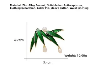 Detail of bamboo leaf brooch with green enamel and white pearls on gold-tone zinc alloy