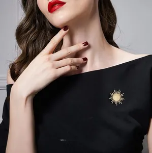 Detail of elegant gold sunburst brooch with opal stone on a black dress fabric