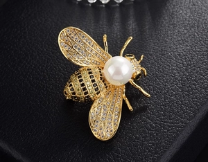 Macro shot of the luxury bee brooch with sparkling crystals and a central white pearl