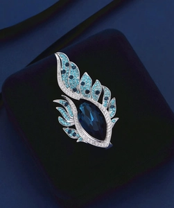 Vue détaillée de la broche avec cristal marquise bleu foncé et pierres scintillantes