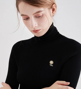 Detailed view of sunflower brooch with rhinestones pinned on a black sweater