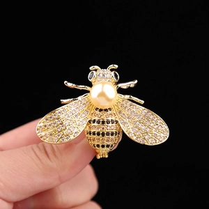 Luxurious bee brooch with gold finish, sparkling rhinestones and a large pearl center