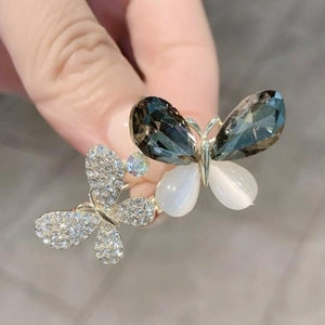 Détail de la broche papillon en cristal avec gemmes grises et base en métal doré