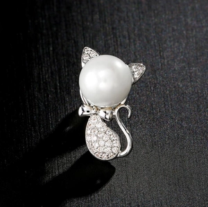 Detail of silver cat brooch with white pearl head and sparkling crystal pave body