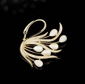 Broche cygne de luxe avec pierre œil-de-chat et cristaux sur surface noire élégante