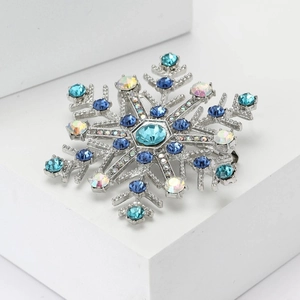 Eleganter silberner Schneeflocken-Anstecker mit blauen und weißen Kristallen auf Basis