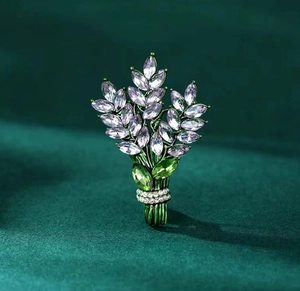 Vue détaillée d'une broche bouquet en cristal lavande sur fond de velours vert foncé