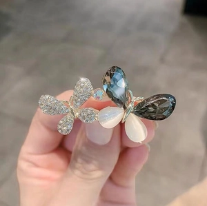 Gros plan détaillé d'une broche papillon avec cristaux gris et opales blanches