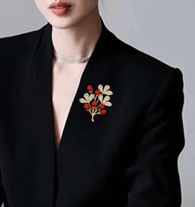 Elegant red berry plant brooch with gold metal and rhinestones on black suit jacket