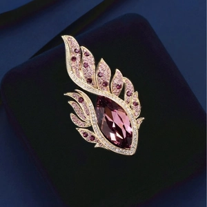 Broche aile d'ange dorée élégante avec zircon violet sur écrin en velours bleu