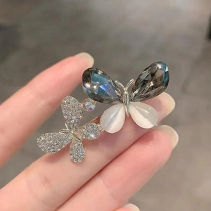 Détail de la broche papillon avec cristal gris et pierre oeil de chat blanche élégante