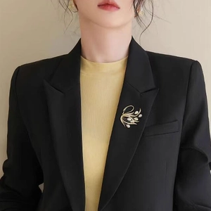 Broche cygne dorée de luxe avec perles blanches sur une veste de costume noire