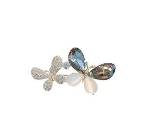 Détails macro d'une broche papillon en cristal avec verre facetté gris et strass argentés