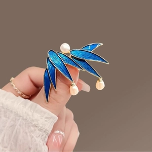 Bamboo leaf brooch with blue enamel and pearls in a vintage gold finish design