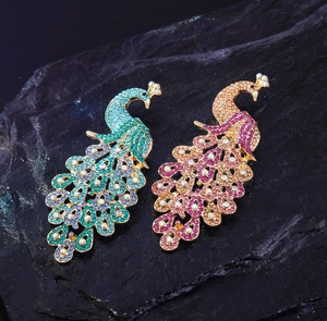 Detailed macro view of peacock brooches with sparkling blue and pink rhinestones