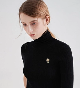 Detail of sunflower brooch with sparkling crystals pinned on black knit turtleneck sweater