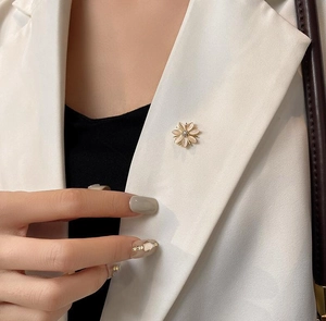 Détail de l'élégante broche fleur en opale avec centre diamant sur un revers