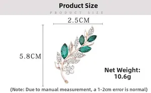 Detailed view of leaf brooch with dimensions 5.8cm x 2.5cm and green gems
