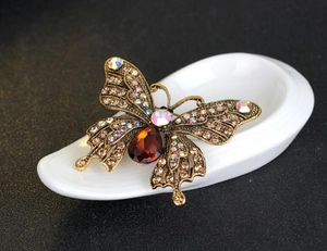 Detail einer Vintage-Schmetterlingsbrosche aus Bronze mit Diamanten und rotem Schmuckstein
